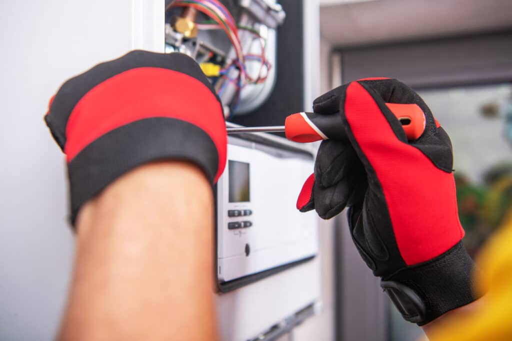 Caucasian HVAC Technician Repairs Broken Gas Heater