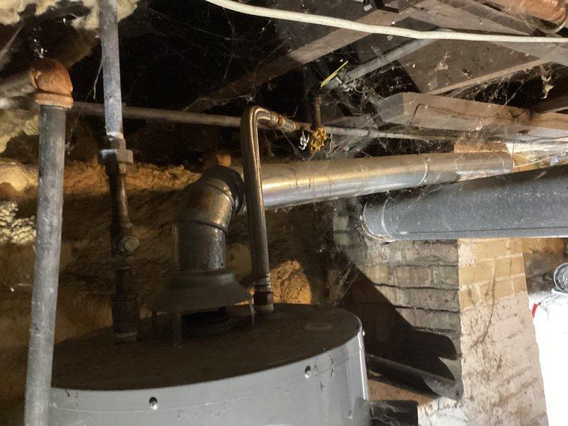 Nappanee, IN - Diagnosed 12-year-old tanked water heater with inoperative burner. Inspection revealed significant dust and cobweb accumulation in the utility area around the unit and associated plumbing infrastructure. No water leakage detected.