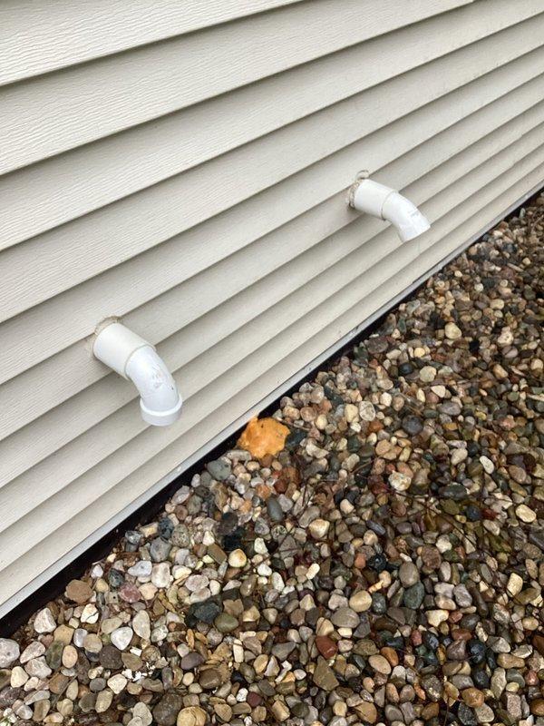Responded to report of slow drip water leak in basement area related to HVAC condensate drainage system. Upon arrival, inspected exterior condensate drain lines and discovered improper drainage from PVC discharge pipes at foundation level. Condensate lines were discharging too close to foundation, causing water infiltration into basement. Verified proper operation of condensate pump and primary drain line. Redirected condensate discharge away from foundation using existing hose connection to prevent further water intrusion. Advised homeowner on proper condensate line maintenance and monitoring for future leaks.
