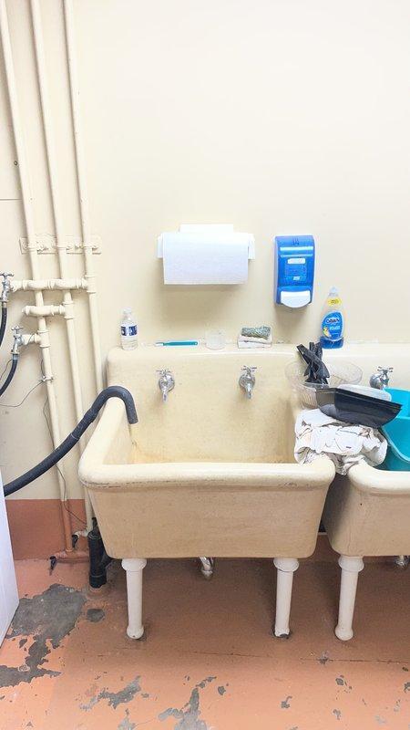 Responded to water leak investigation at commercial facility. Inspected exterior drainage system at building foundation where downspout showed signs of corrosion and water accumulation at base, with soil erosion evident around discharge point. Evaluated interior utility sink area and associated plumbing infrastructure, documenting condition of PVC supply lines and shut-off valves for maintenance coordination as requested.