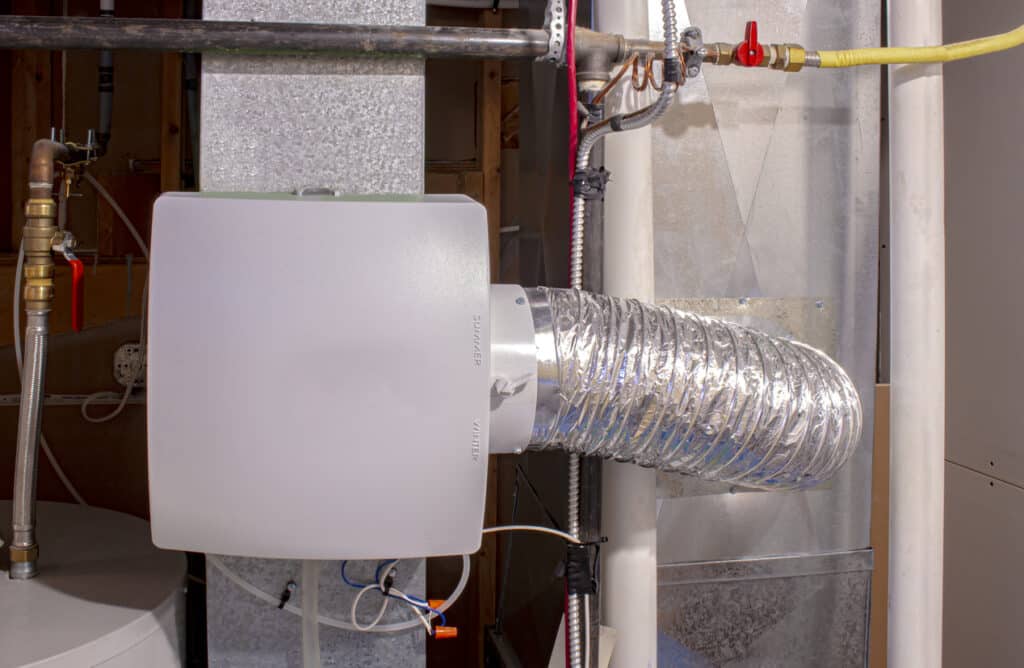 A home humidifier attached to the return duct with a bypass connection to the supply hot air duct