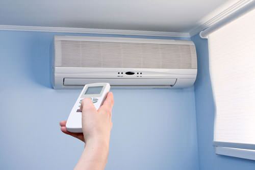 Person using remote for ductless mini-split