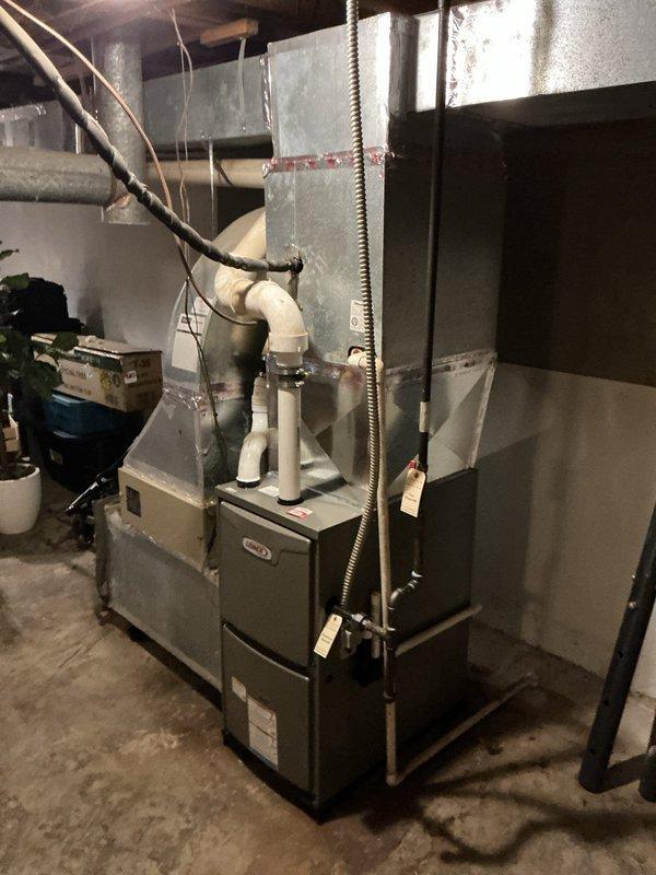 Successfully installed a Lennox ML196UH070 furnace with 16x25x1 filter elbow and T4 thermostat in customer's utility area. Completed proper ductwork connections with seam tape at joints and installed PVC drain piping. System is operational with all components properly secured and labeled.