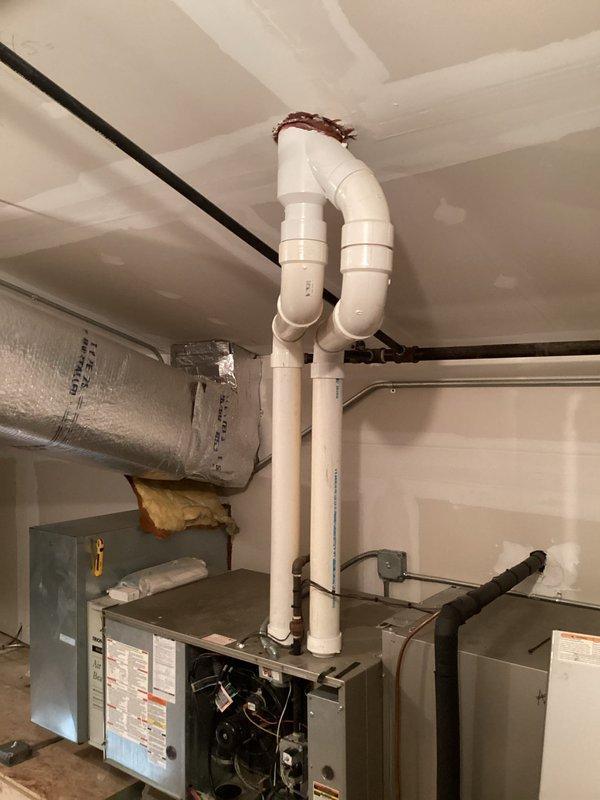 Performed follow-up service call for heating system not maintaining set temperature (72°F set, 64°F actual). Inspected drainage system previously serviced for water backup in inducer motor. Found PVC condensate drain line properly connected to floor drain with no current blockages. Examined furnace with panels removed to verify inducer motor operation and confirmed proper draft. System is now heating correctly with no water accumulation in components.