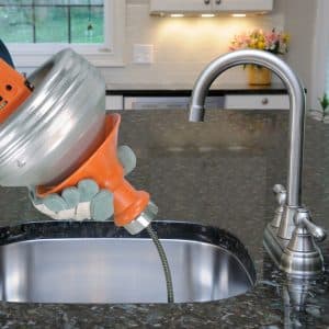 Plumber snaking kitchen sink drain