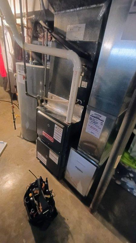 Performed scheduled air conditioning tune-up service on residential HVAC system located in basement utility room. Inspected furnace unit, associated ductwork, and PVC ventilation piping - all components in normal working condition with no visible damage. Additionally, customer reported unusually high hot water temperatures from water heater; documented issue for potential follow-up service.