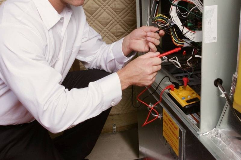 HVAC technician working on furnace