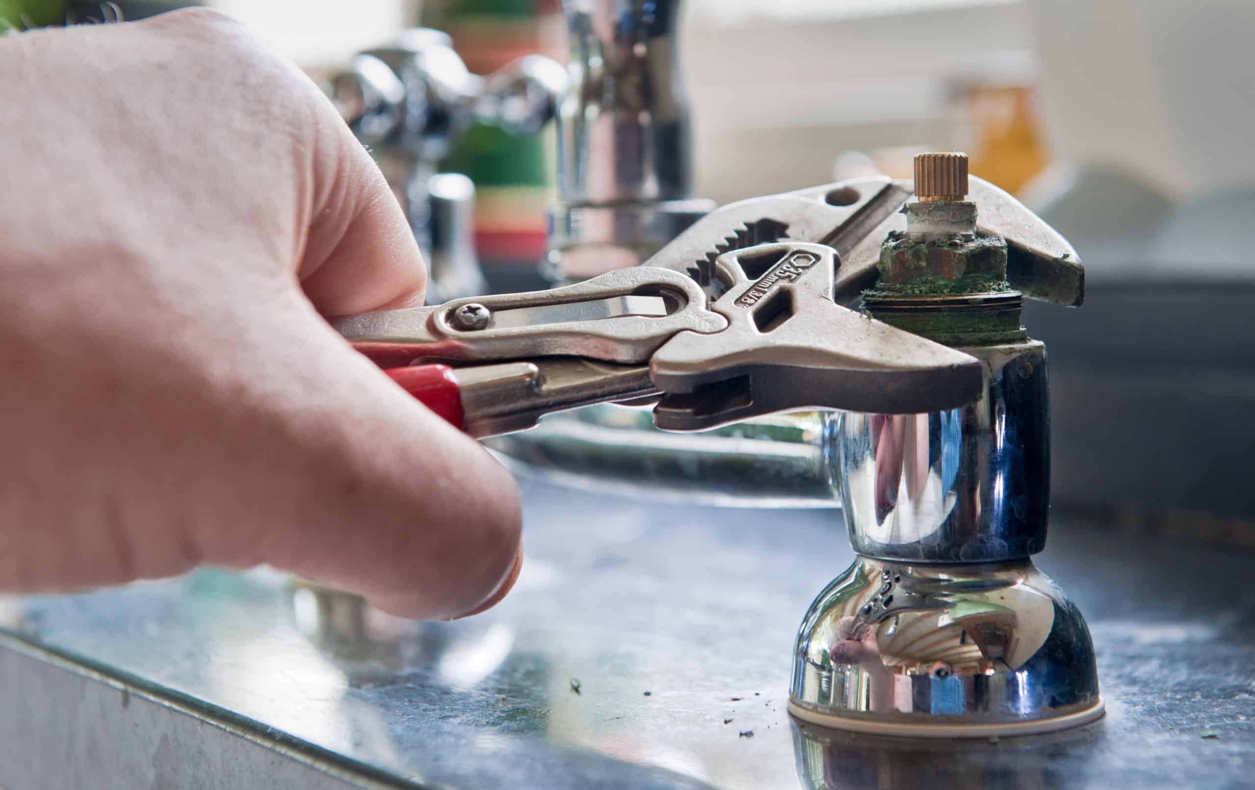 Plumber using wrench on sink part