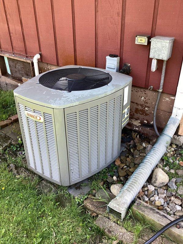 # HVAC Maintenance - Planned Single Maintenance

Completed scheduled air conditioning maintenance on residential Lennox condensing unit. Performed comprehensive system inspection including examination of condenser coils, electrical components, and refrigerant lines. Cleaned accumulated debris, leaves, and dirt from base of unit and surrounding area. Inspected heat exchanger coils which showed signs of weathering and dirt accumulation requiring attention. Verified proper operation of fan assembly and checked electrical disconnect box. Documented equipment condition through photographic evidence showing outdoor installation against wooden fence with PVC drainage line and electrical connections. Unit operational upon completion of maintenance service.
