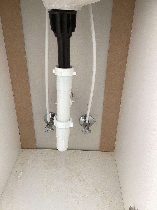Completed final plumbing installation including setting toilet with supply line connection, installing lavatory with PVC drainage assembly and chrome shut-off valves, trimming shower faucet, and setting kitchen sink. Connected all plumbing fixtures to existing well tank system, filled water heater, and tested full system operation to verify proper function. All fixtures installed per code and confirmed operational at time of completion.
