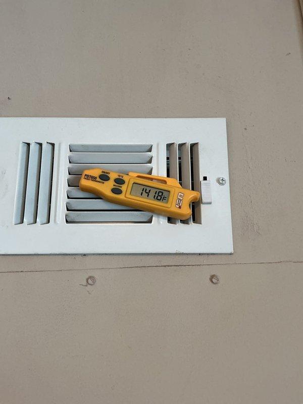 Completed installation of Lennox EL297UH070 furnace, successfully connecting unit to existing thermostat and return air filter system. Post-installation temperature testing confirmed proper system operation with readings at 14.8°F at the register. Installation includes properly configured PVC ventilation pipes with secure connection points.