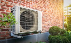 heat pump outdoor unit against brick wall