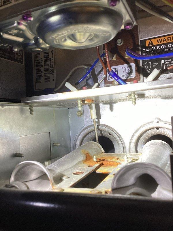 Diagnosed 16-year-old HVAC system that was running intermittently and blowing cold air. Inspection revealed significant corrosion and rust on critical components including the heat exchanger and electrical connections. Determined system failure due to age-related deterioration of metal surfaces and compromised electrical terminals. Recommended replacement of system due to safety concerns and efficiency issues.