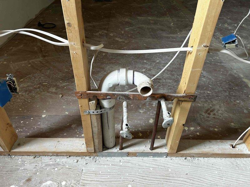 Conducted on-site assessment for plumbing estimate regarding steam shower installation and general replumbing requirements. Inspected exposed wall structures with existing insulation, vapor barriers, and current PVC drain/vent pipe configuration. Evaluated rough-in plumbing needs and identified necessary modifications to accommodate requested steam shower installation.
