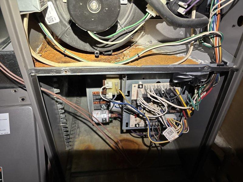 Goshen, IN - Performed diagnostic inspection on aging HVAC system (10+ years old) responding to no-heat complaint. Accessed furnace interior, examined blower assembly and electrical components, noting accumulated dust and potential rust formation. Inspected control board and wiring connections, with particular attention to the electrical harnesses showing signs of wear. System restored to proper heating function after service.