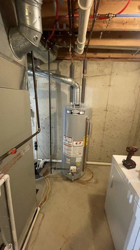Goshen, IN - Successfully completed water heater replacement as quoted, installing a new cylindrical silver/gray unit with proper copper pipe connections to existing plumbing system in the utility area.
