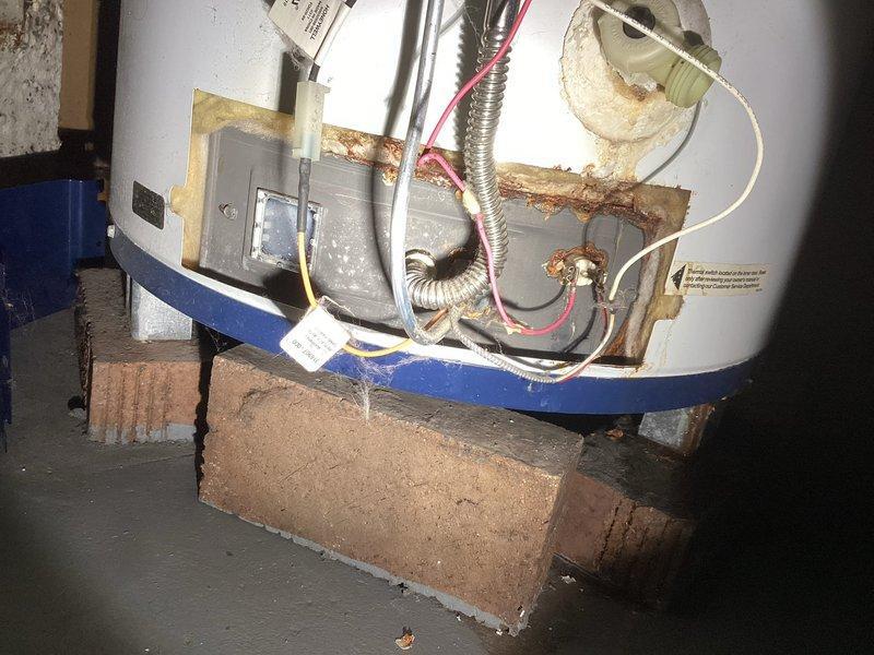 Responded to service call for a tanked water heater with non-functioning pilot light. Upon inspection, found significant corrosion and rust around the connection points and control area. Diagnosed failed thermocouple and gas valve issues requiring complete unit replacement as previously estimated due to age and deterioration of the existing system.