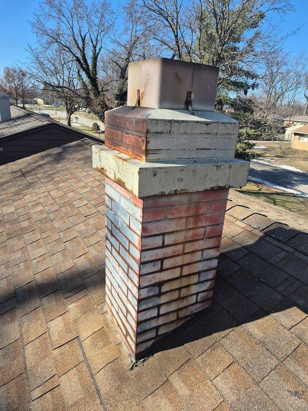 Conducted a site assessment to evaluate the existing chimney system for B-vent replacement. Documented the current installation with detailed photos of both the rooftop brick chimney structure and the attic connection point where wooden joists meet the metal ductwork. Noted signs of possible moisture issues and aging on both the wooden structural elements and the weathered brick chimney exterior.