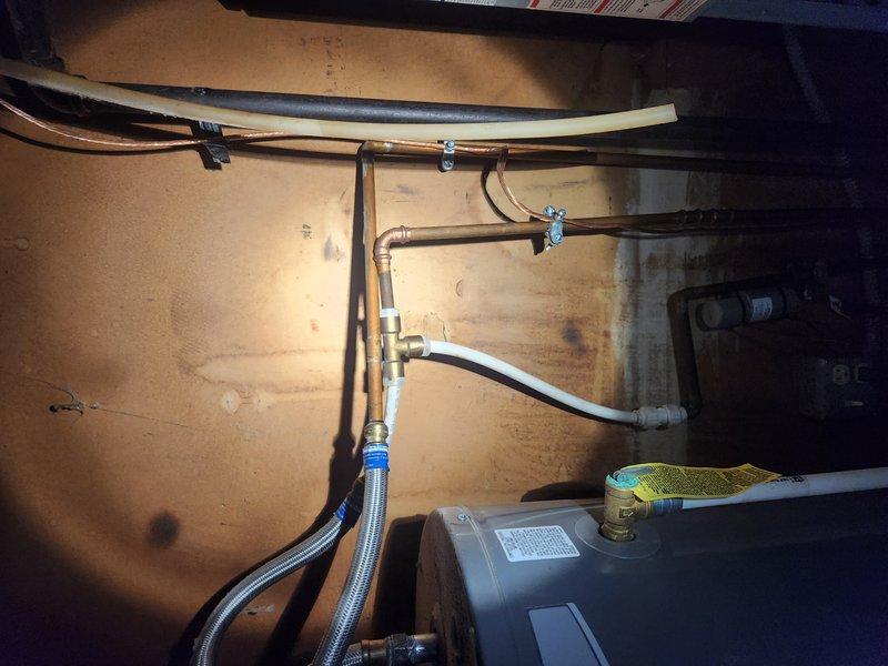 Conducted comprehensive inspection of utility closet plumbing system, identifying broken pipes and assessing water damage to surrounding walls. Evaluated existing copper supply lines, PVC drainage components, and brass fittings for functionality and code compliance. Documented exposed plumbing infrastructure in bathroom/utility area requiring renovation, including deteriorated floor tiles and compromised wooden framing around plumbing penetrations.