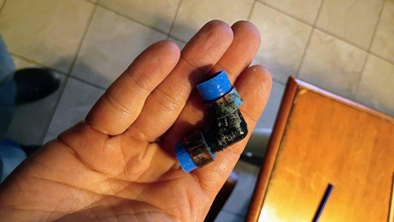 Responded to water leak in laundry room with water supply already shut off by customer. Upon inspection, identified failed sensor module on water supply line causing active leak. Accessed plumbing through floor cavity to locate source of leak on blue PEX water line with brass compression fitting connection. Removed defective electronic sensor component from water supply system. Repaired compromised section of water line and replaced faulty connection point. Verified all connections were secure and leak-free before restoring water supply. Tested system under full pressure to confirm repair integrity. No standing water present at time of service or upon completion.